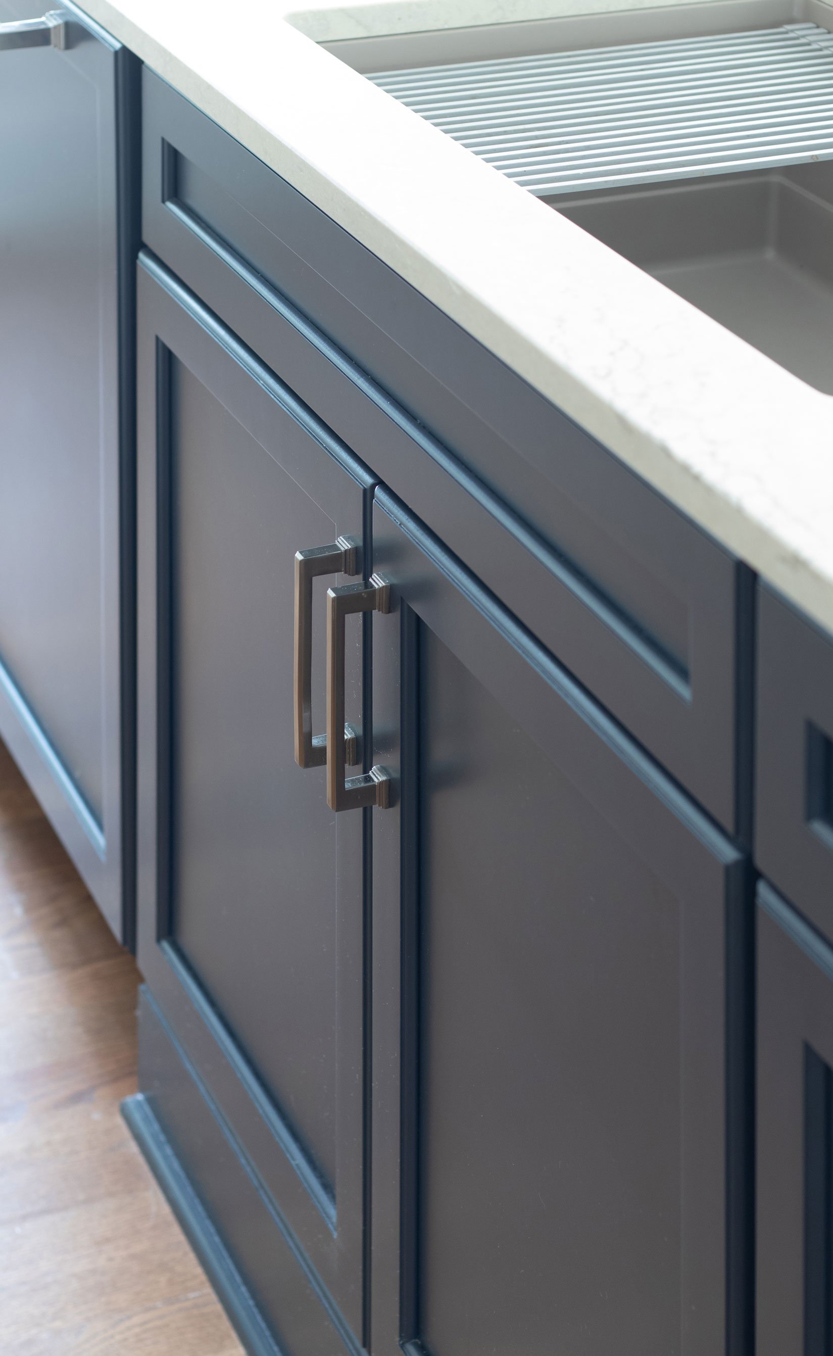 Deep blue cabinetry on kitchen island featuring workstation sink.