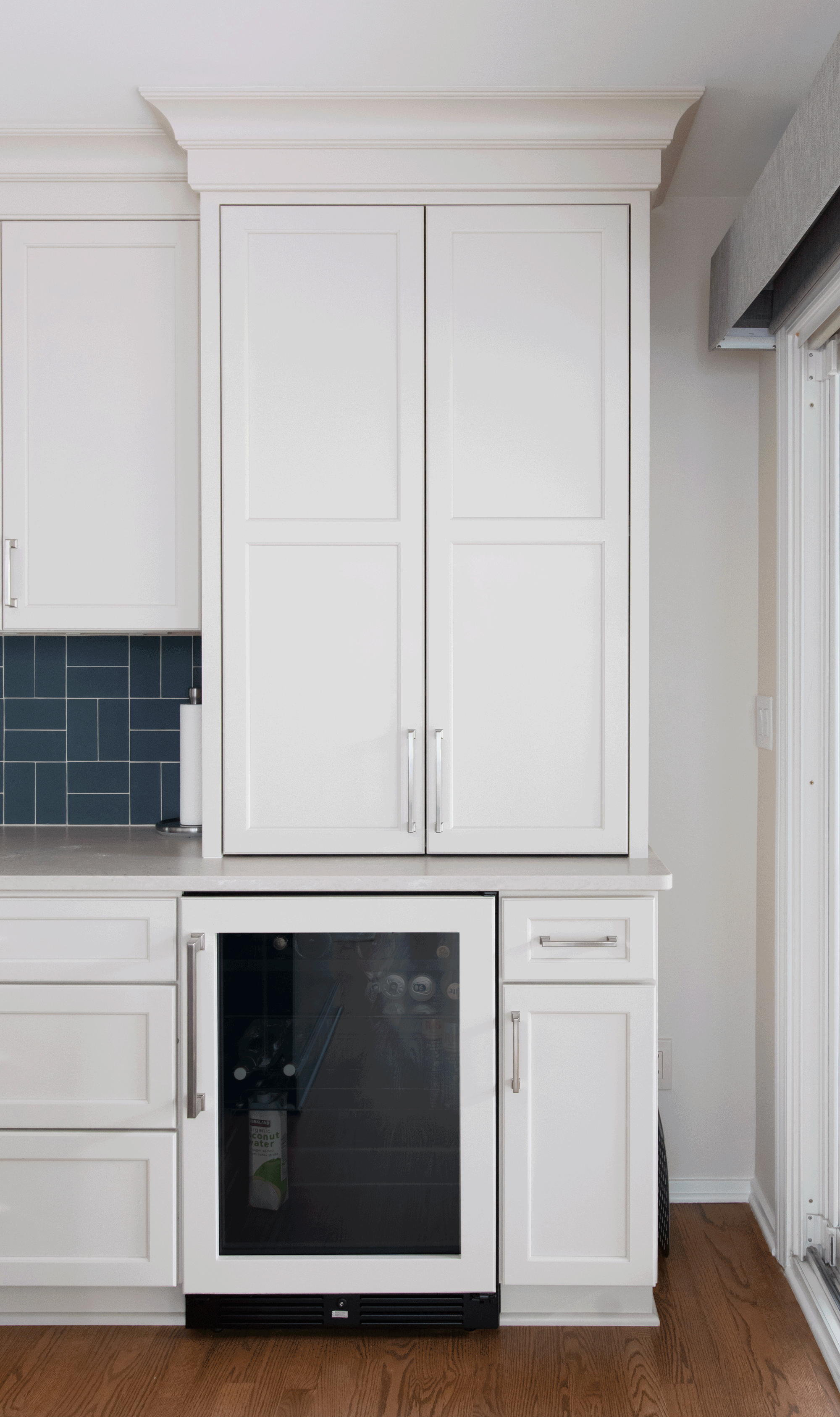 Hidden coffee station with retractable pocket doors, beverage refrigerator, and custom storage cabinetry.
