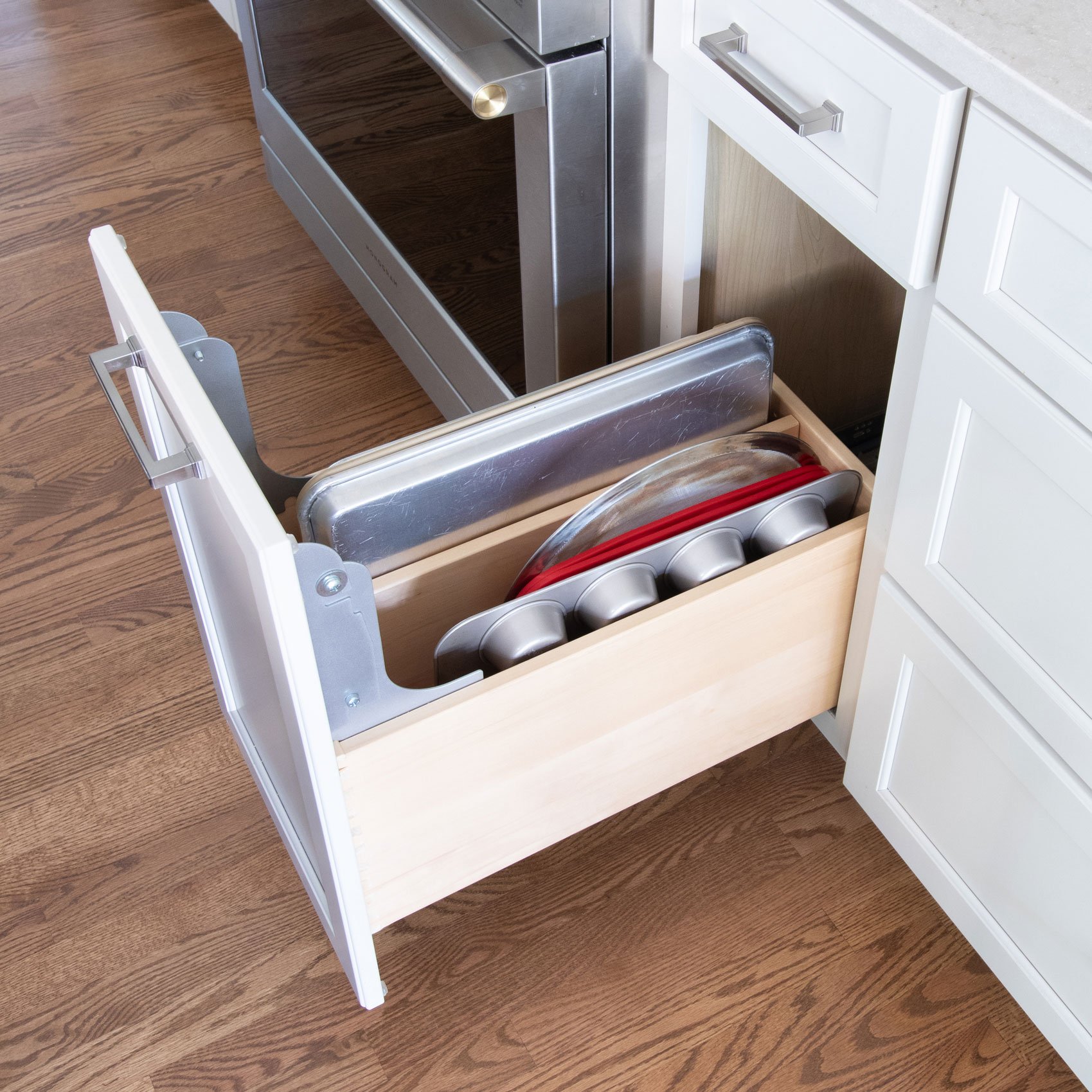 Custom cabinet organizer with vertical storage for baking sheets, trays, and cookware.