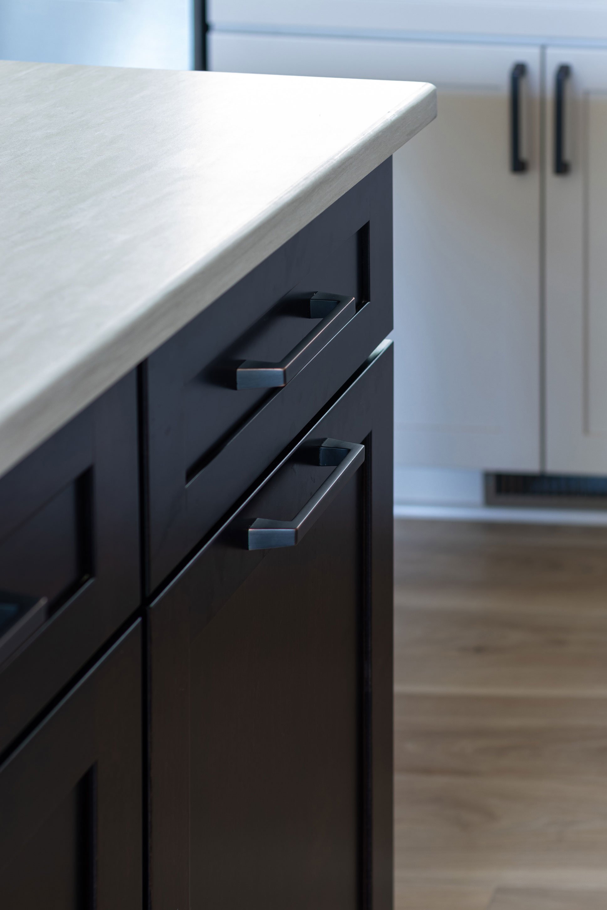 Detail of dark island cabinetry with oil-rubbed bronze bar pulls.
