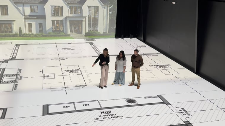 KSI designer Sandra Daubenmeyer walks a projected full-scale floor plan with a client and KSI Appliance Manager Josh Miller at TrueScale Studio.