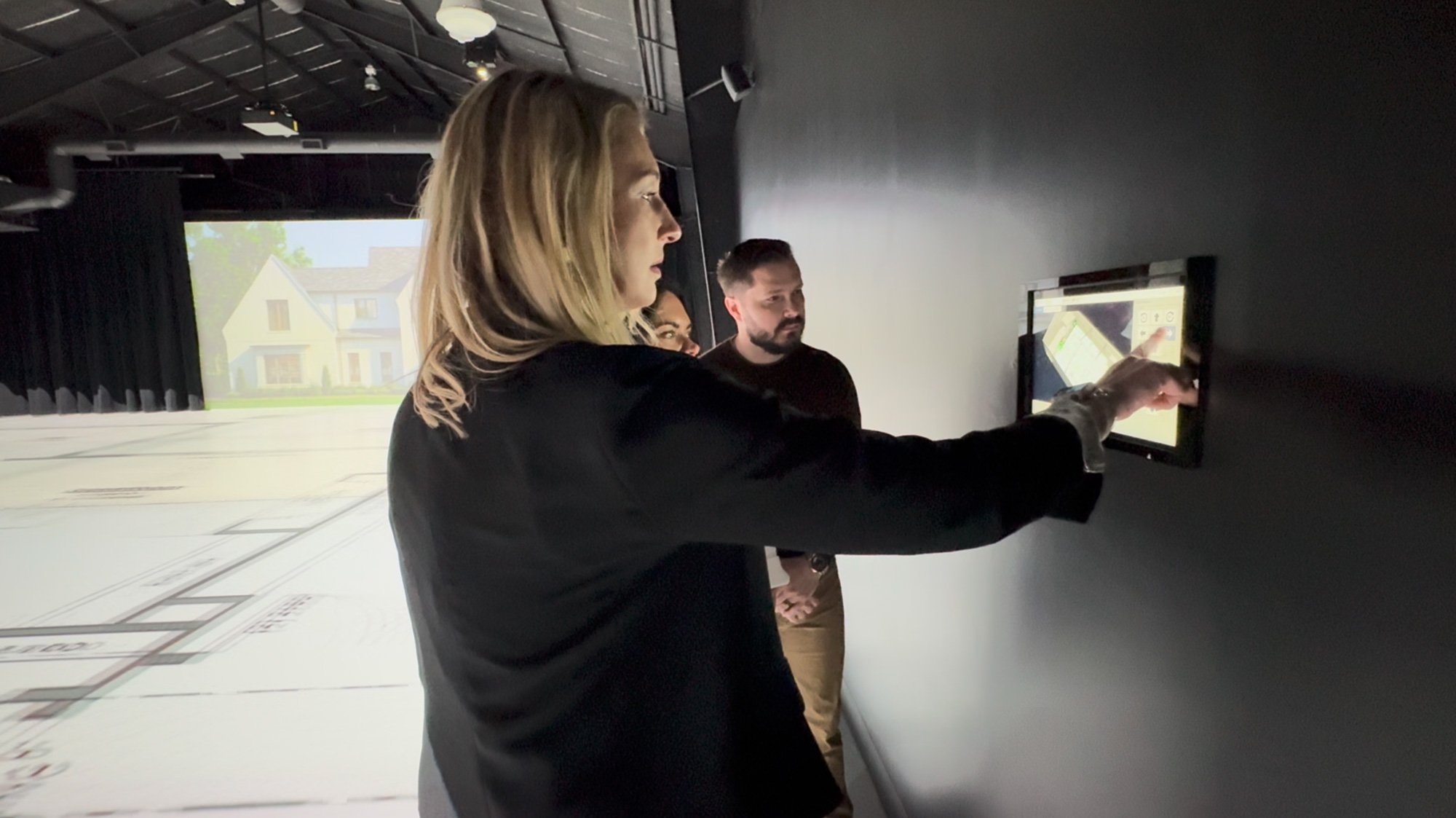 Sandra Daubenmeyer reviews and adjusts floor plan details on a touchscreen interface during an immersive design session at TrueScale Studio.